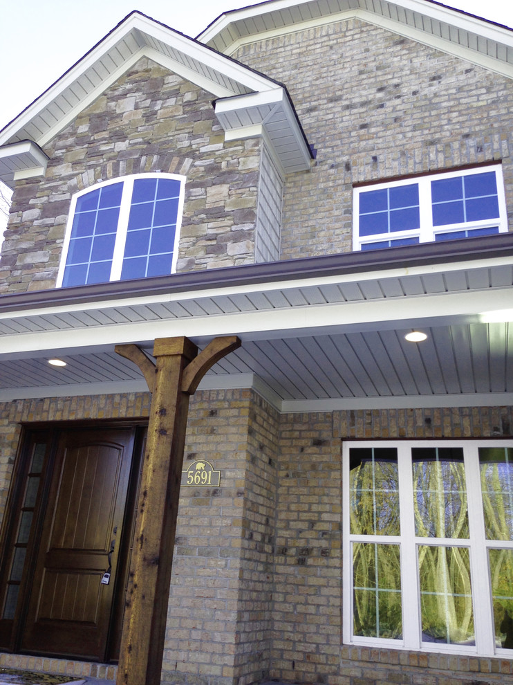 This is an example of a large traditional two-storey brick beige exterior in Other with a gable roof.