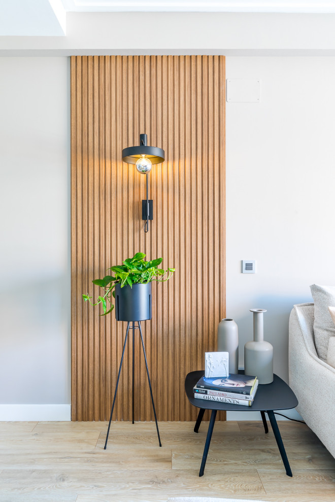 Mittelgroßes, Abgetrenntes Modernes Wohnzimmer in grau-weiß mit grauer Wandfarbe, hellem Holzboden, freistehendem TV, braunem Boden und Holzwänden in Madrid