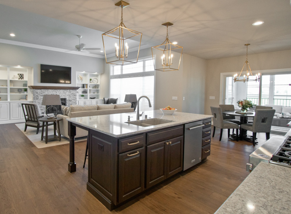 This is an example of a transitional eat-in kitchen in Other with an undermount sink, raised-panel cabinets, dark wood cabinets, quartz benchtops, stainless steel appliances, medium hardwood floors, with island, brown floor and white benchtop.