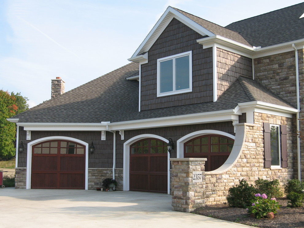 Transitional two-storey brown exterior in Cleveland with stone veneer.