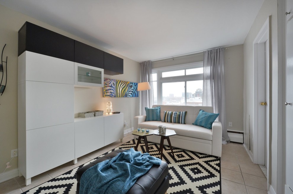 Living room - small modern open concept ceramic tile living room idea in Montreal with beige walls and a media wall
