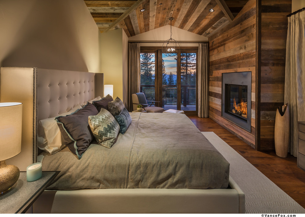 Inspiration pour une chambre d'amis chalet de taille moyenne avec un mur beige, un sol en bois brun, une cheminée standard, un manteau de cheminée en bois et un sol marron.