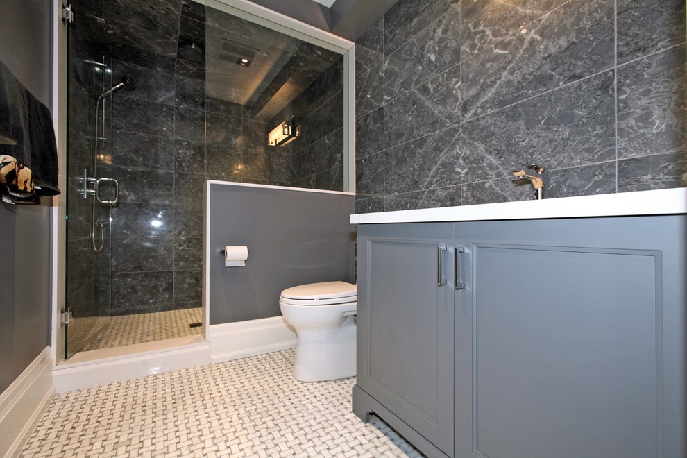 Inspiration for a mid-sized transitional 3/4 bathroom in Toronto with recessed-panel cabinets, grey cabinets, an alcove shower, a two-piece toilet, gray tile, porcelain tile, grey walls, porcelain floors, an undermount sink, solid surface benchtops, white floor and a hinged shower door.