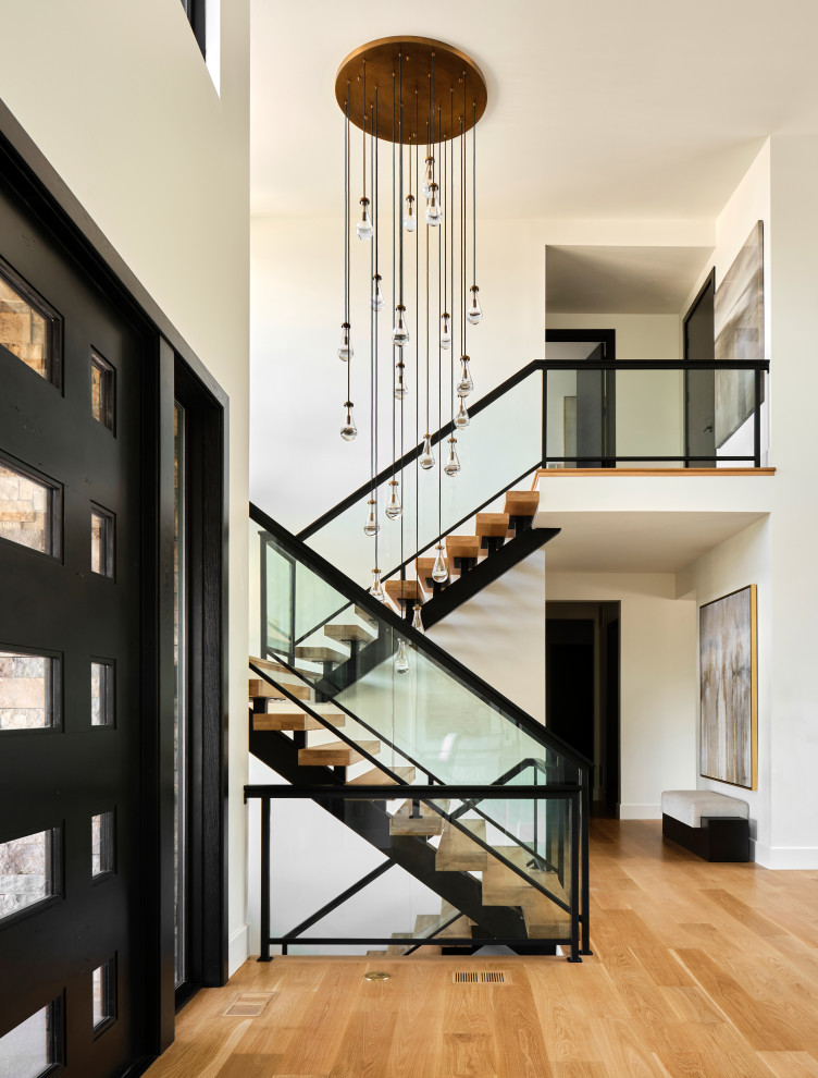 Huge trendy wooden u-shaped glass railing staircase photo in Denver with wooden risers