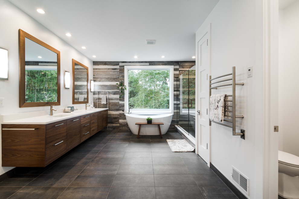 Contemporary master bathroom in Detroit with flat-panel cabinets, medium wood cabinets, a freestanding tub, an alcove shower, brown tile, white walls, an undermount sink, brown floor, a hinged shower door and white benchtops.