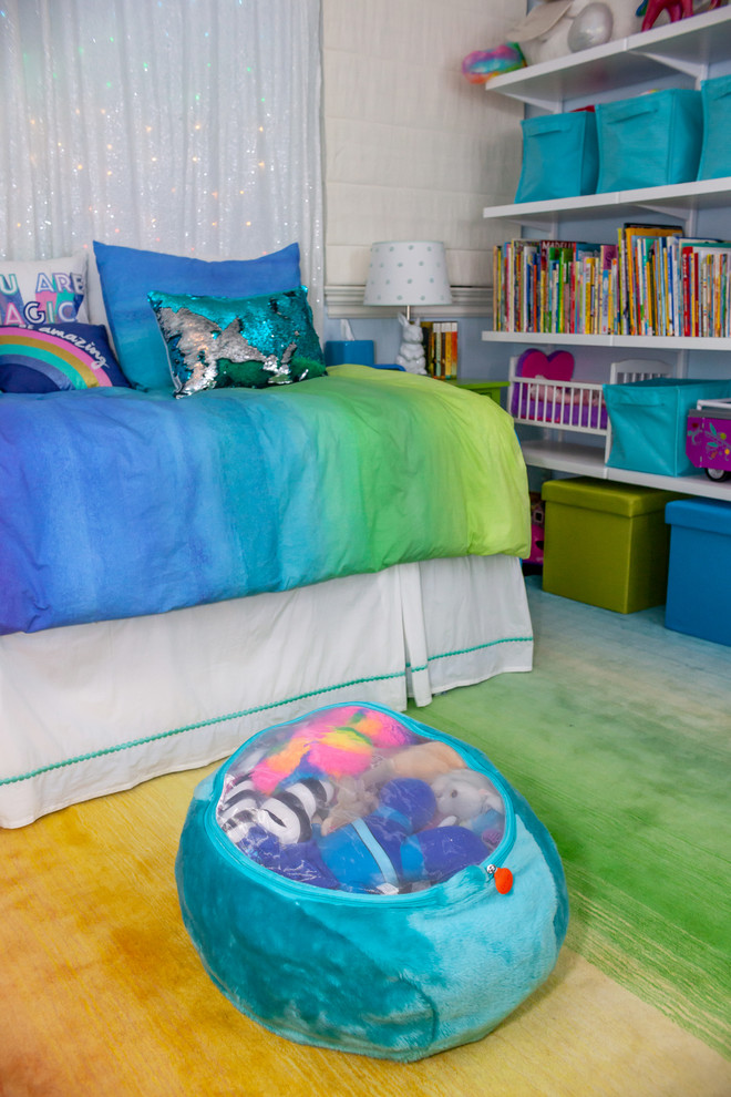 This is an example of a mid-sized kids' bedroom for kids 4-10 years old and girls in Los Angeles with blue walls, carpet and multi-coloured floor.