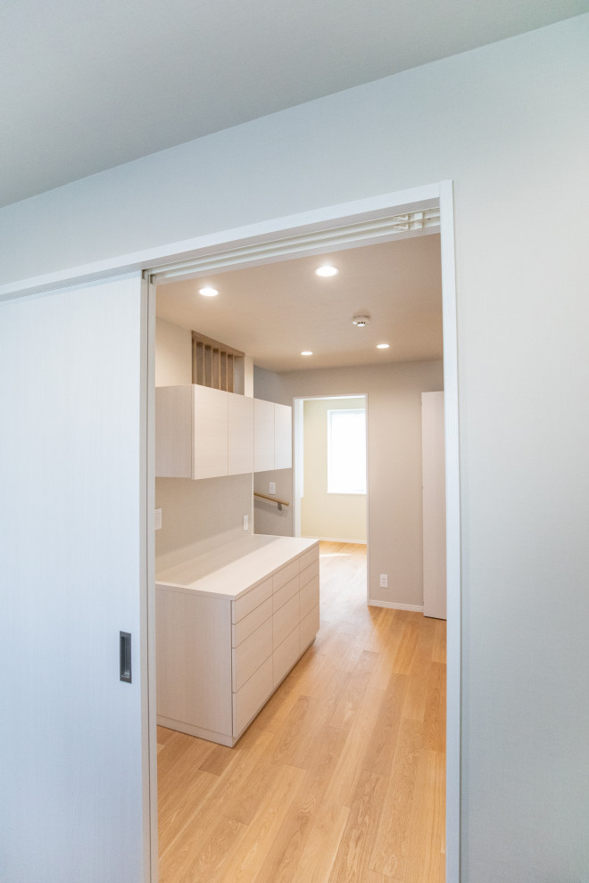 Cette photo montre une petite salle de séjour moderne ouverte avec un mur gris, parquet clair, un sol beige, un plafond en papier peint et du papier peint.