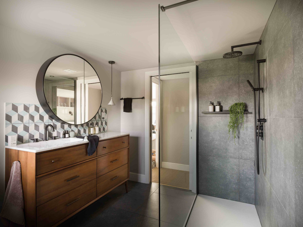 Inspiration for a mid-sized contemporary 3/4 bathroom in Essex with medium wood cabinets, a double shower, multi-coloured tile, cement tile, grey walls, a drop-in sink, marble benchtops, grey floor, an open shower, a single vanity and a freestanding vanity.