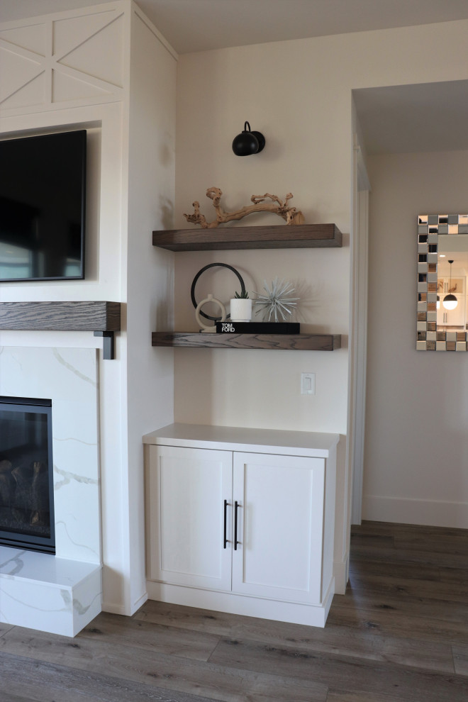 Example of a large transitional l-shaped medium tone wood floor and brown floor open concept kitchen design with a single-bowl sink, shaker cabinets, white cabinets, quartz countertops, gray backsplash, subway tile backsplash, stainless steel appliances, an island and white countertops