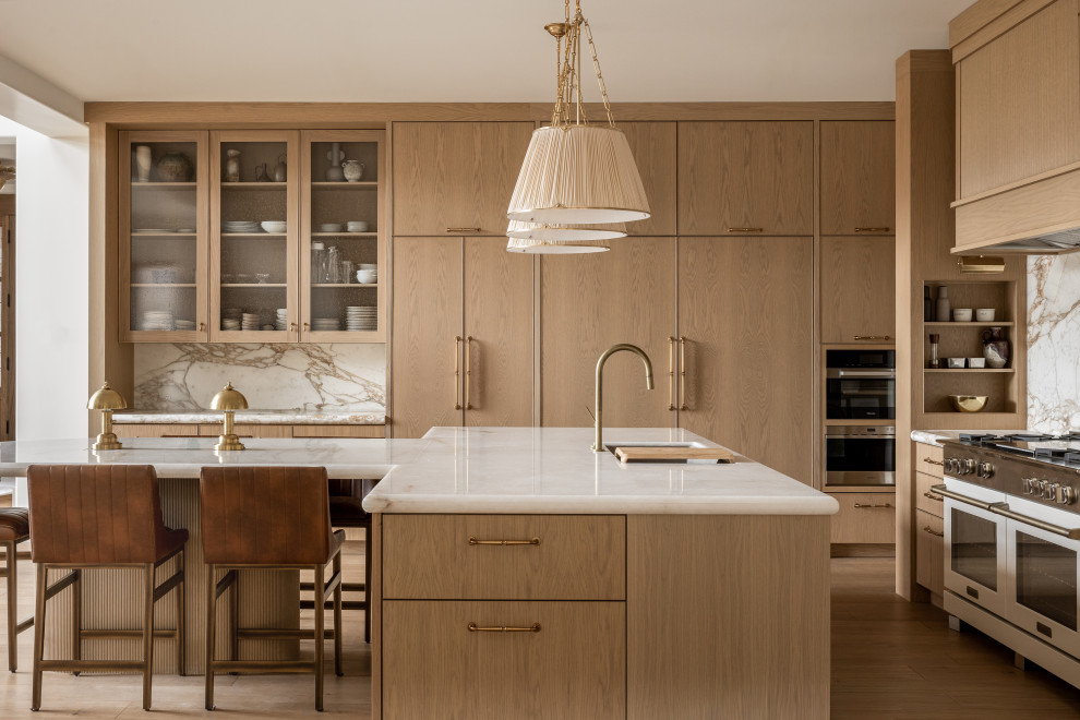 Example of a huge transitional l-shaped light wood floor and beige floor kitchen design in Salt Lake City with an undermount sink, flat-panel cabinets, light wood cabinets, white backsplash, stone slab backsplash, white appliances, an island and white countertops