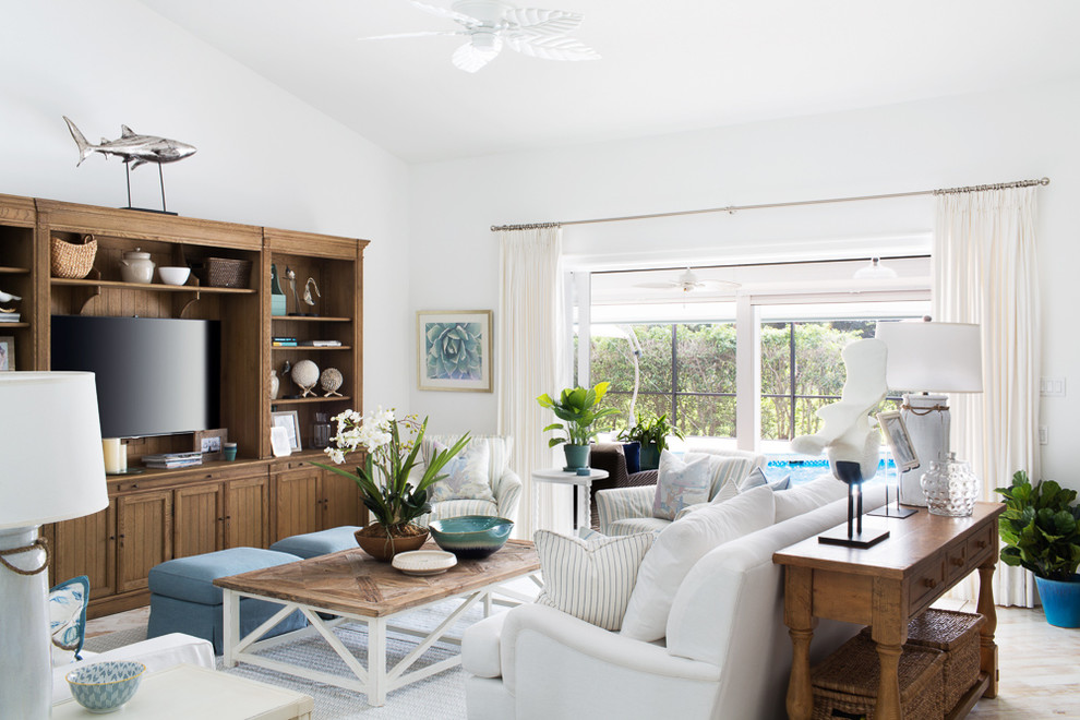 This is an example of a large beach style open concept family room in Miami with white walls, light hardwood floors, a built-in media wall, no fireplace and brown floor.