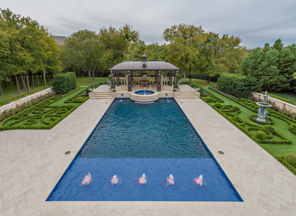 Large traditional rectangular pool in Dallas with a water feature.