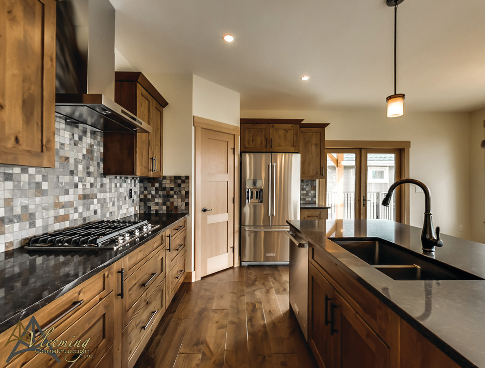 This is an example of a mid-sized arts and crafts u-shaped open plan kitchen in San Diego with a double-bowl sink, shaker cabinets, medium wood cabinets, multi-coloured splashback, stone tile splashback, stainless steel appliances, dark hardwood floors and with island.