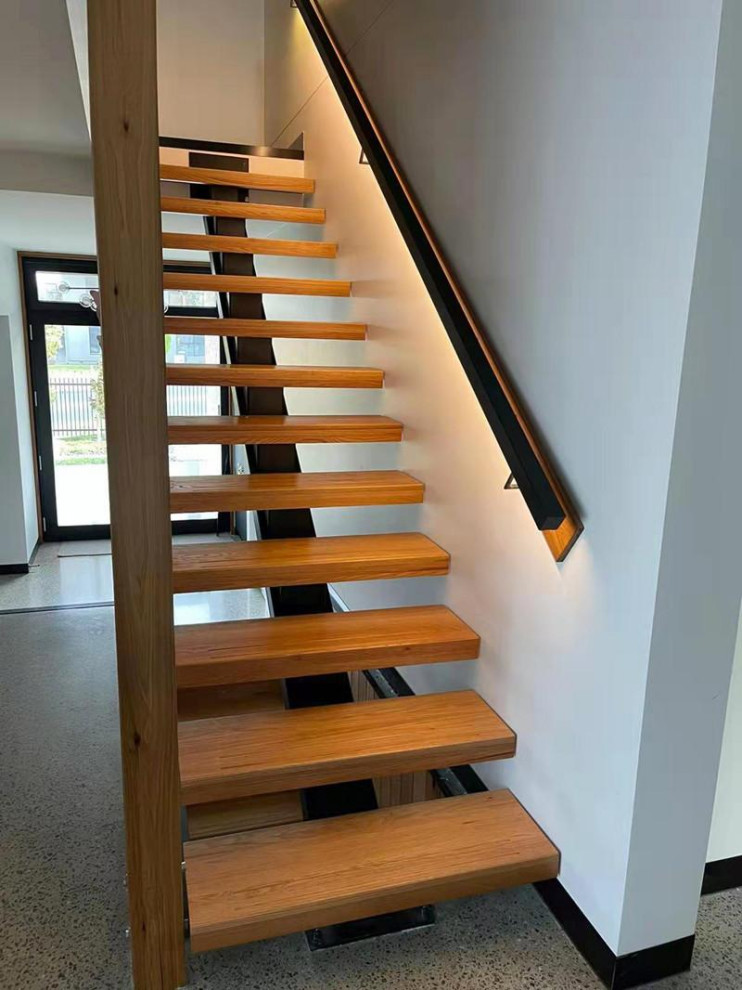 Foto de escalera recta moderna de tamaño medio sin contrahuella con escalones de madera, barandilla de vidrio y papel pintado
