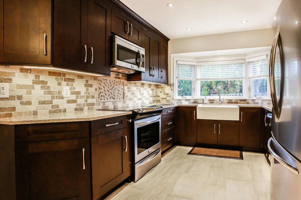 Mid-sized transitional u-shaped porcelain tile enclosed kitchen photo in Toronto with a farmhouse sink, shaker cabinets, dark wood cabinets, quartz countertops, beige backsplash, stone tile backsplash, stainless steel appliances and no island