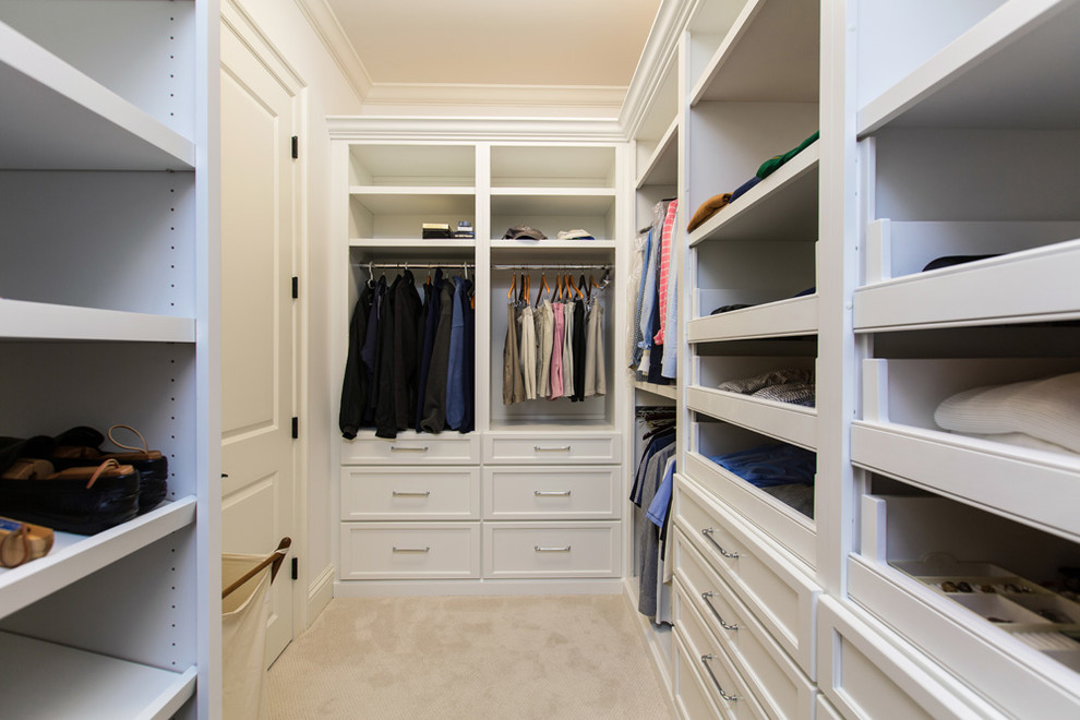 This is an example of a large transitional gender-neutral walk-in wardrobe in Miami with flat-panel cabinets, white cabinets and carpet.