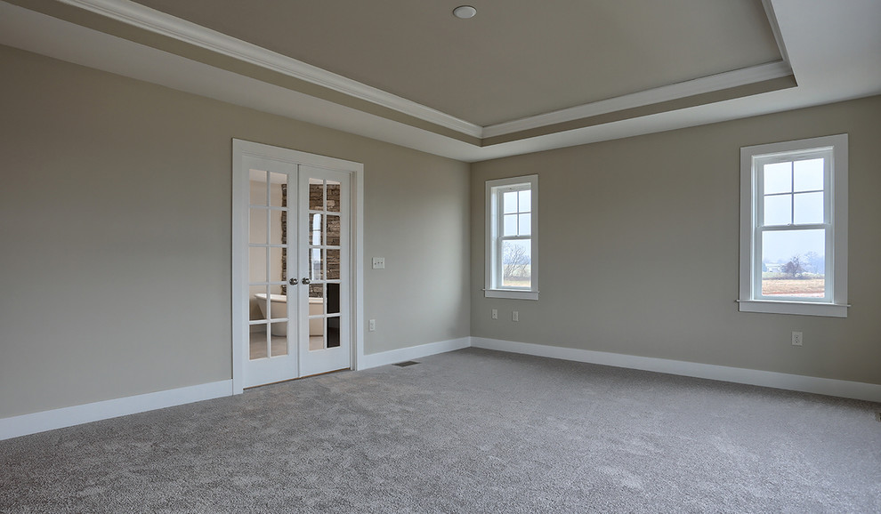 This is an example of a large transitional master bedroom in Other with beige walls and carpet.