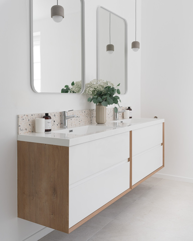 Inredning av ett modernt stort vit vitt en-suite badrum, med släta luckor, vita skåp, ett fristående badkar, en öppen dusch, en vägghängd toalettstol, gul kakel, keramikplattor, vita väggar, klinkergolv i keramik, ett integrerad handfat, laminatbänkskiva, beiget golv och med dusch som är öppen