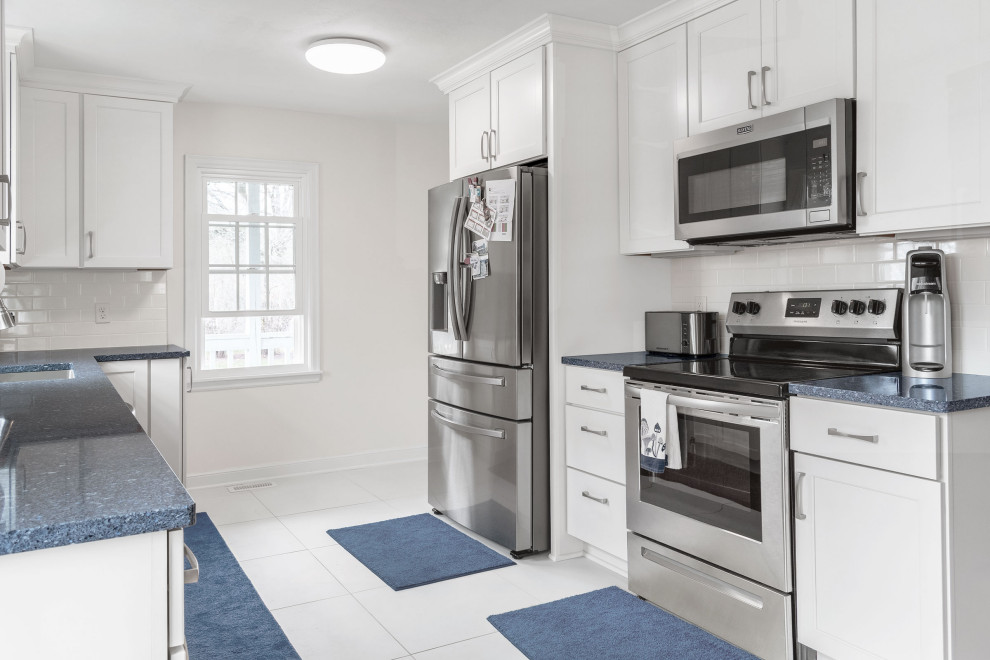 This is an example of a small traditional galley kitchen/diner in Minneapolis with a submerged sink, flat-panel cabinets, white cabinets, engineered stone countertops, white splashback, metro tiled splashback, stainless steel appliances, ceramic flooring, no island, white floors and blue worktops.