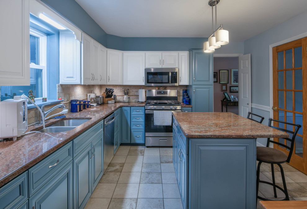 Mid-sized transitional l-shaped separate kitchen in Baltimore with an undermount sink, recessed-panel cabinets, blue cabinets, granite benchtops, beige splashback, stone tile splashback, stainless steel appliances, ceramic floors, with island, beige floor and orange benchtop.