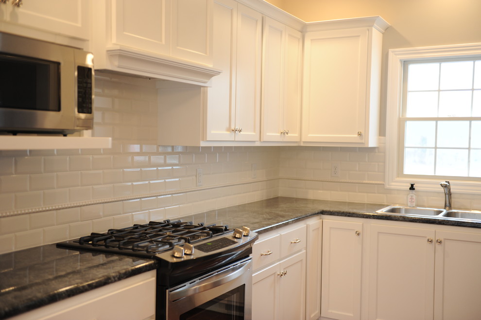 Eat-in kitchen - transitional u-shaped eat-in kitchen idea in Chicago with a drop-in sink, flat-panel cabinets, white cabinets, laminate countertops, white backsplash and subway tile backsplash