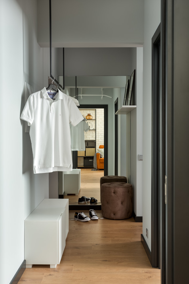 This is an example of a small scandinavian hallway in Moscow with grey walls, laminate floors and brown floor.