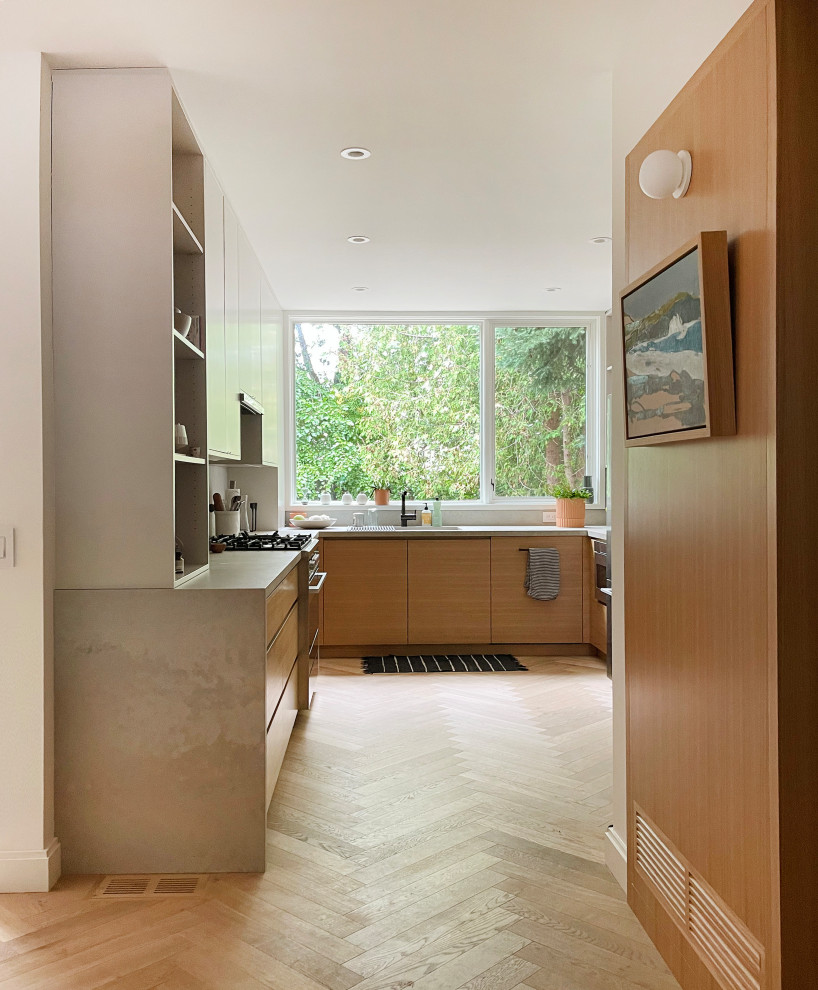 Modern inredning av ett avskilt, mellanstort grå grått u-kök, med en undermonterad diskho, släta luckor, skåp i mellenmörkt trä, bänkskiva i kvarts, grått stänkskydd, rostfria vitvaror, ljust trägolv och brunt golv
