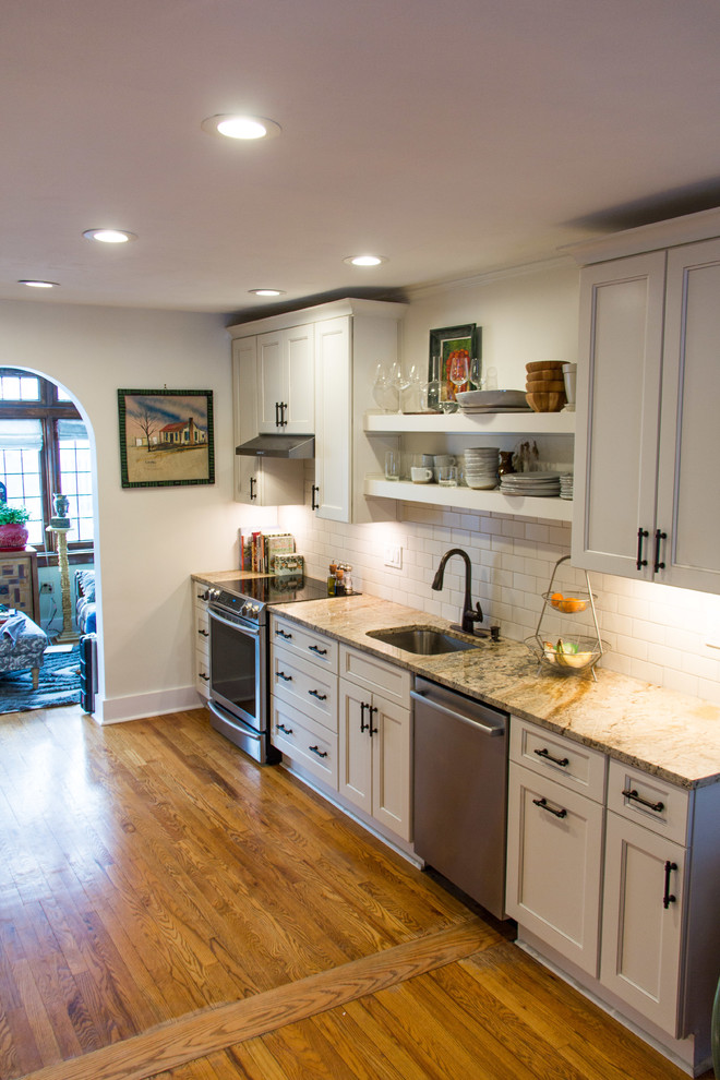 Inspiration for a transitional medium tone wood floor kitchen remodel with granite countertops, subway tile backsplash and stainless steel appliances