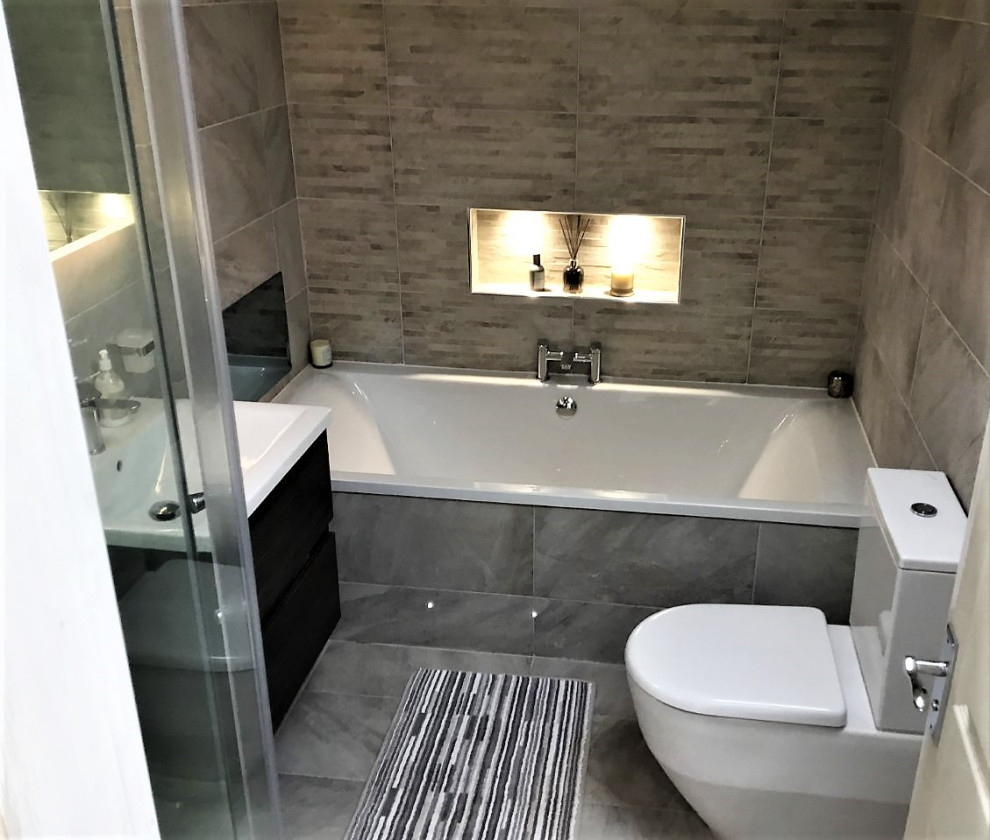 Inspiration för mellanstora moderna en-suite badrum, med släta luckor, ett platsbyggt badkar, en hörndusch, grå kakel, porslinskakel, grå väggar, klinkergolv i porslin, grått golv och dusch med skjutdörr