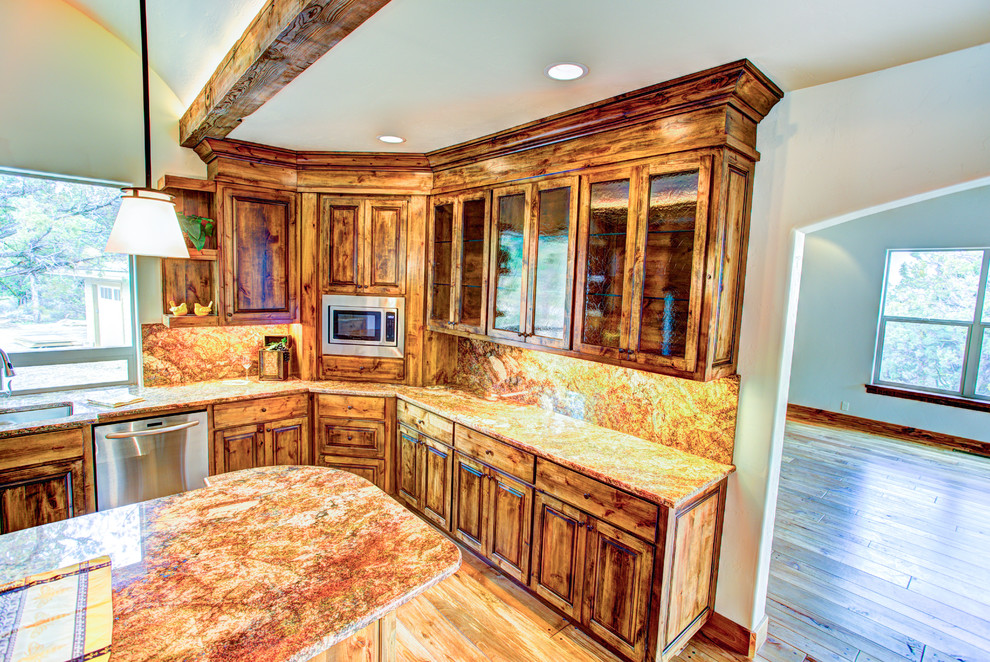 Kitchen pantry - large rustic u-shaped medium tone wood floor kitchen pantry idea with a drop-in sink, glass-front cabinets, medium tone wood cabinets, beige backsplash, stainless steel appliances and an island