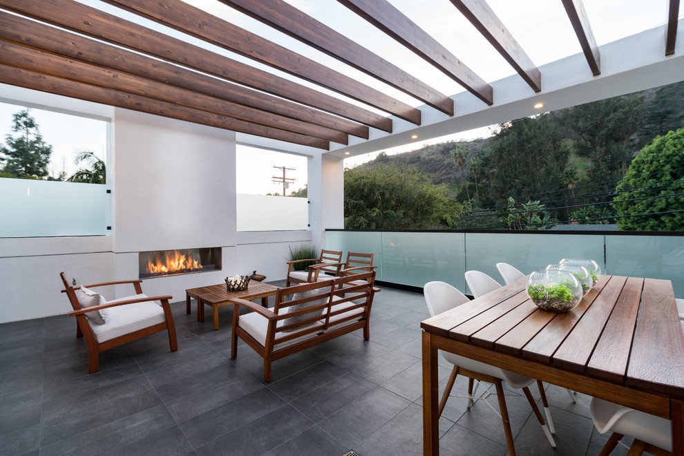 Inspiration for a contemporary rooftop and rooftop deck in Los Angeles with a fire feature and a pergola.