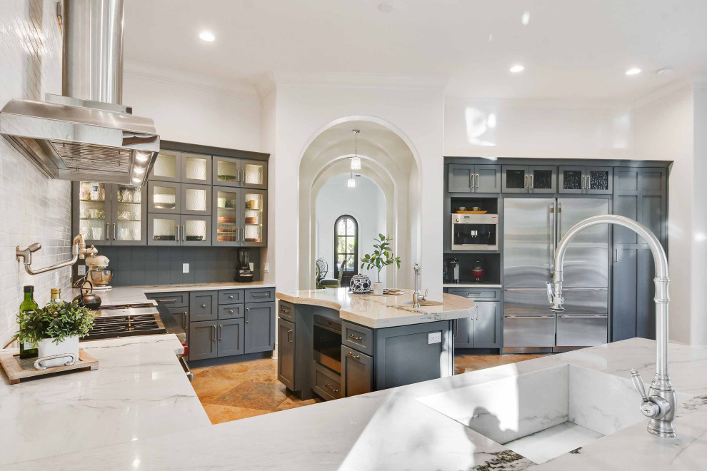 Inspiration for an expansive mediterranean u-shaped eat-in kitchen in Orlando with grey cabinets, marble benchtops, white splashback, stainless steel appliances, with island, an integrated sink, orange floor and grey benchtop.