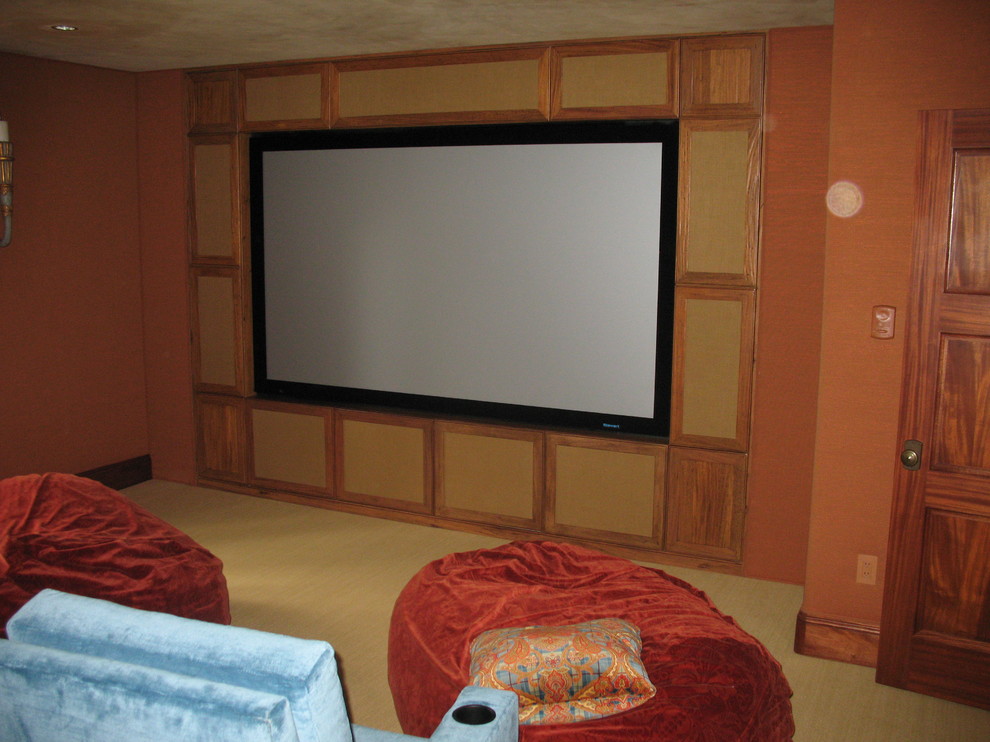 Inspiration for a mid-sized traditional open concept home theatre in Denver with a built-in media wall, orange walls and carpet.