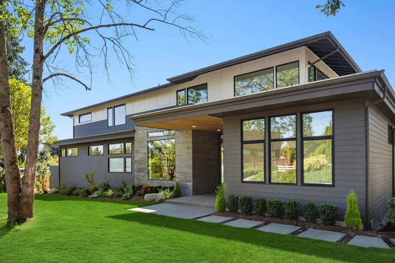 Inspiration for a mid-sized modern two-storey grey exterior in Dallas with wood siding, a gambrel roof, a metal roof, a black roof and board and batten siding.