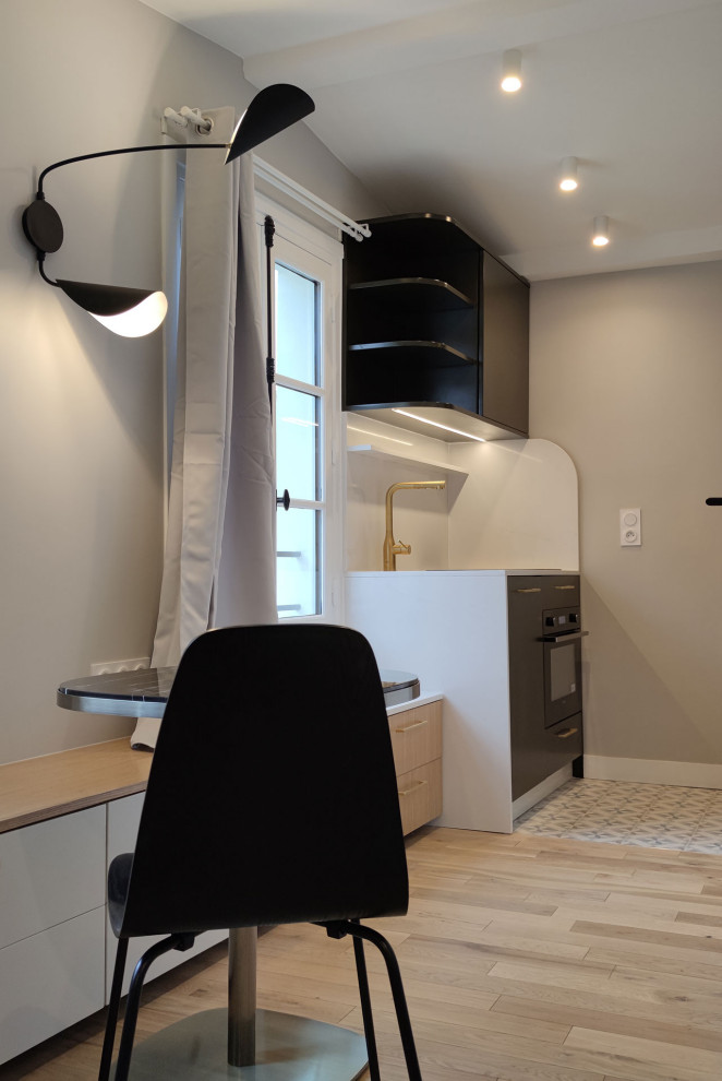 Photo of a small contemporary galley open plan kitchen in Paris with a single-bowl sink, beaded inset cabinets, dark wood cabinets, quartzite benchtops, white splashback, engineered quartz splashback, panelled appliances, cement tiles, no island, white floor and white benchtop.
