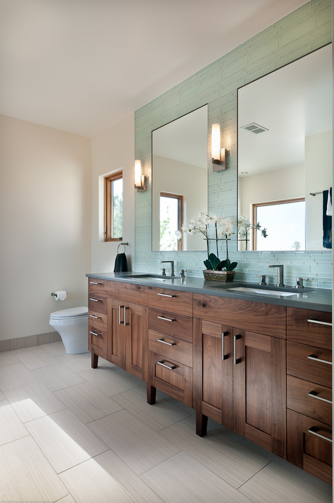 Photo of a transitional bathroom in Denver with shaker cabinets, blue tile, matchstick tile, dark wood cabinets and grey benchtops.