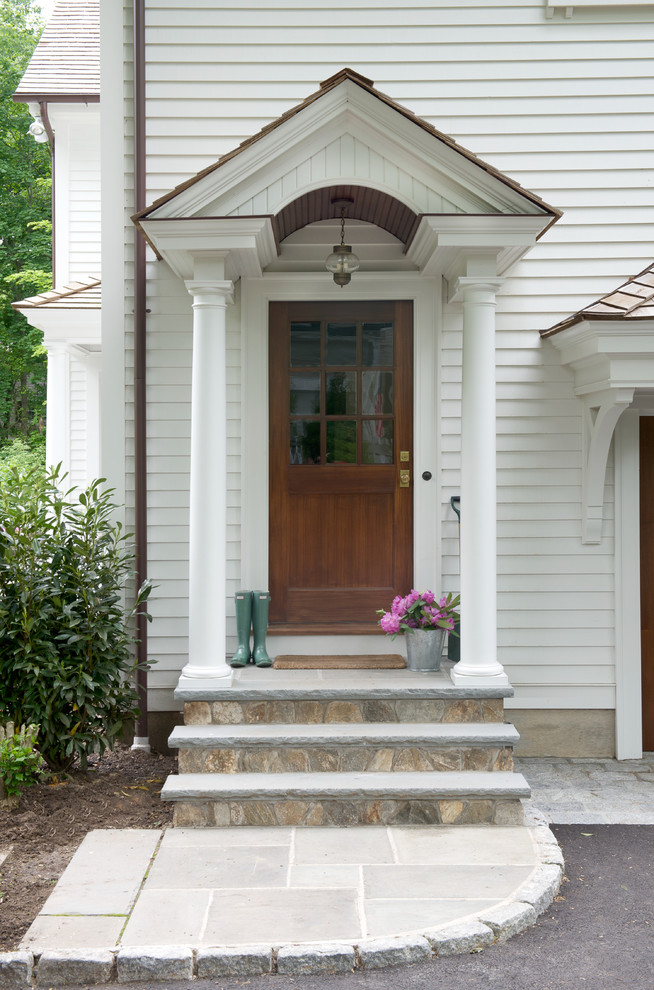 Foyer - large traditional medium tone wood floor foyer idea in New York with white walls and a dark wood front door