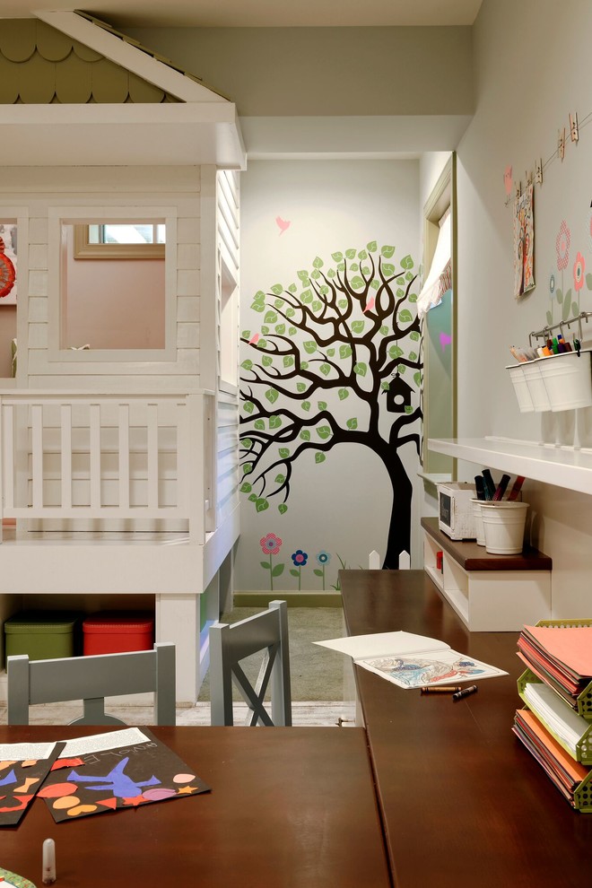 Creative and Unique Playroom - A perfect playroom space for two young girls to grow into.  The space contains a custom made playhouse, complete with hidden trap door, custom built in benches with plenty of toy storage and bench cushions for reading, lounging or play pretend.  In order to mimic an outdoor space, we added an indoor swing.  The side of the playhouse has a small soft area with green carpeting to mimic grass, and a small picket fence.  The tree wall stickers add to the theme.  A huge highlight to the space is the custom designed, custom built craft table with plenty of storage for all kinds of craft supplies.  The rustic laminate wood flooring adds to the cottage theme.
Bob Narod Photography