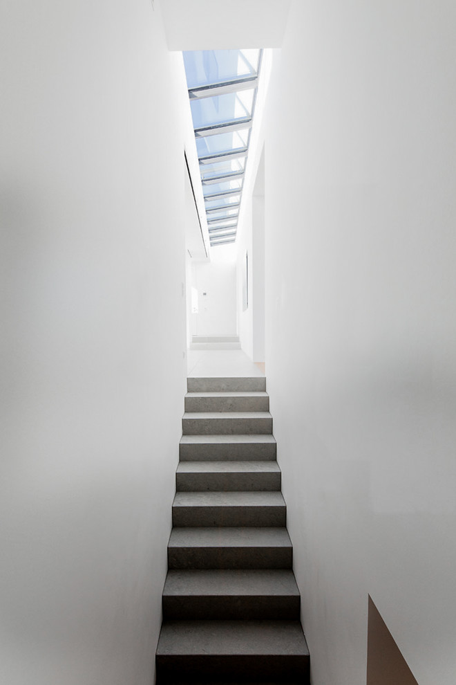 Large modern concrete straight staircase in Stuttgart with concrete risers.