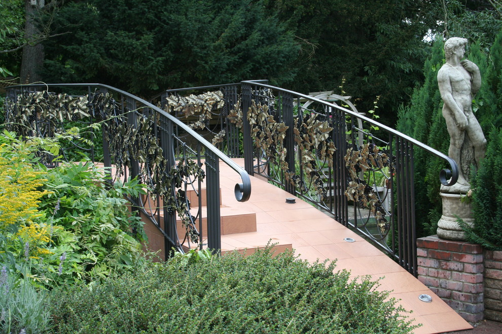 Réalisation d'un jardin à la française arrière bohème de taille moyenne et au printemps avec une exposition ensoleillée, des pavés en pierre naturelle et une clôture en métal.