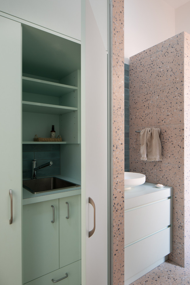 Стильный дизайн: главная ванная комната среднего размера со стиральной машиной в стиле фьюжн с плоскими фасадами, зелеными фасадами, накладной ванной, открытым душем, раздельным унитазом, розовой плиткой, каменной плиткой, розовыми стенами, полом из терраццо, настольной раковиной, столешницей из ламината, розовым полом, открытым душем, зеленой столешницей, тумбой под одну раковину и встроенной тумбой - последний тренд