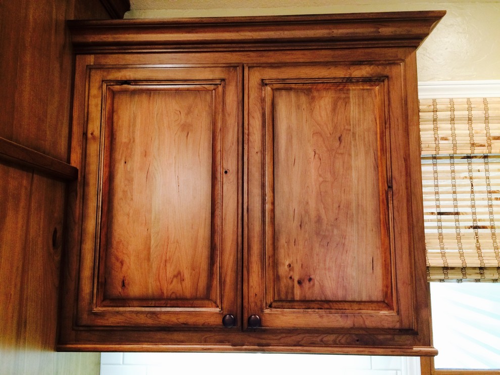 Eat-in kitchen - mid-sized traditional l-shaped porcelain tile eat-in kitchen idea with an undermount sink, raised-panel cabinets, medium tone wood cabinets, granite countertops, beige backsplash, porcelain backsplash, stainless steel appliances and an island