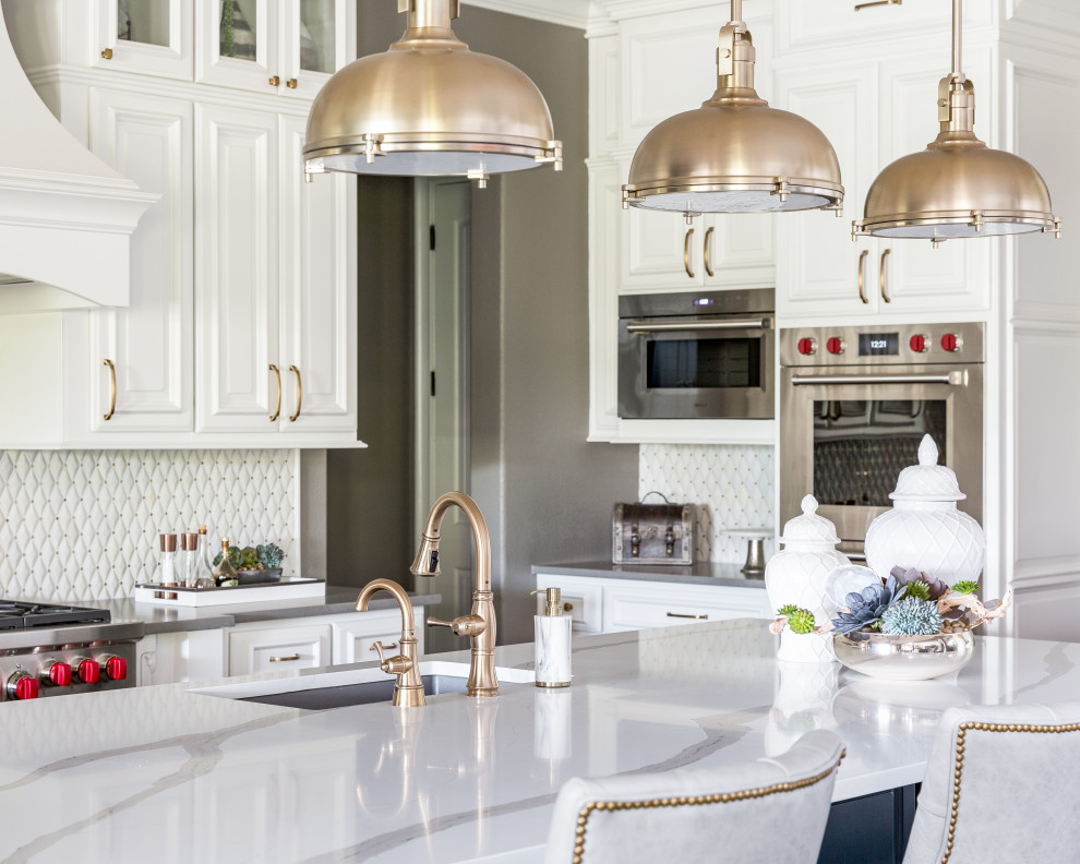 Transitional l-shaped kitchen photo in Houston with an undermount sink, raised-panel cabinets, white cabinets, gray backsplash, stainless steel appliances, an island and white countertops