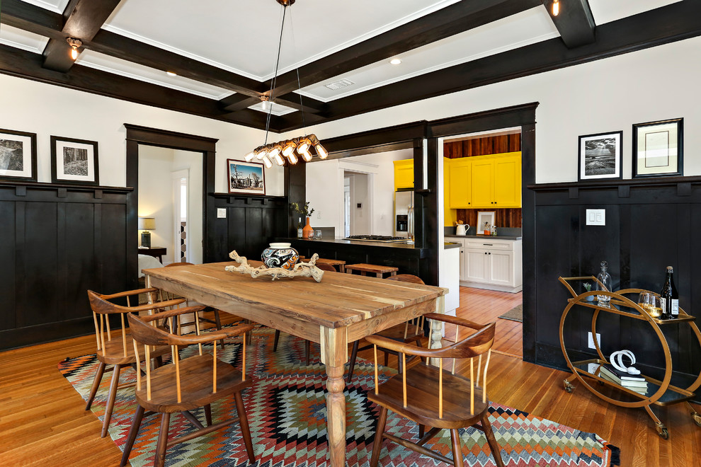 Eclectic separate dining room in Los Angeles with white walls, medium hardwood floors and brown floor.