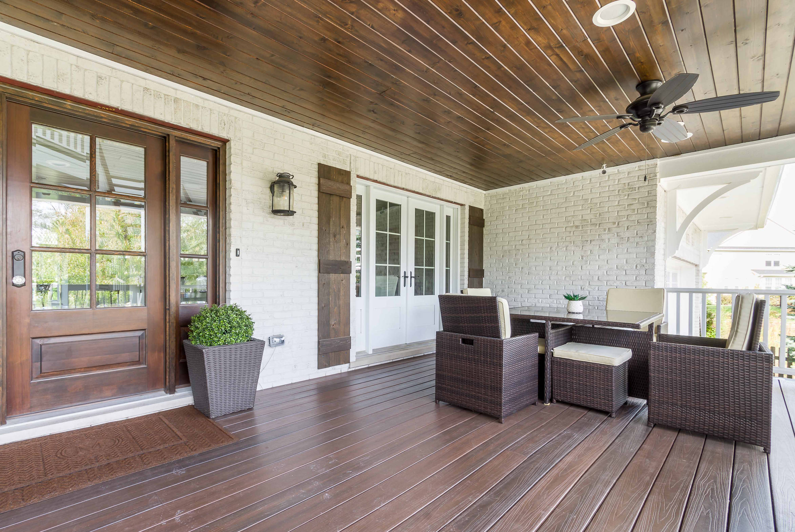 Island Inspiration - front porch lanai with wood floor and ceiling, wicker table and chairs