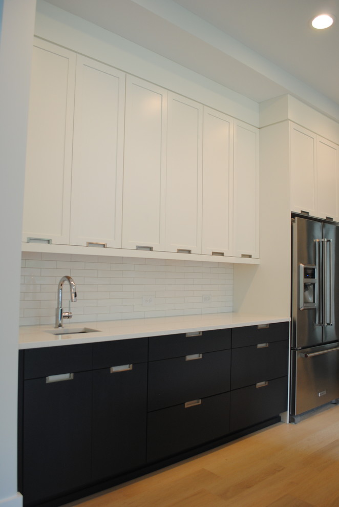 Design ideas for a mid-sized scandinavian single-wall wet bar in Raleigh with an undermount sink, flat-panel cabinets, white cabinets, quartz benchtops, white splashback, subway tile splashback and light hardwood floors.