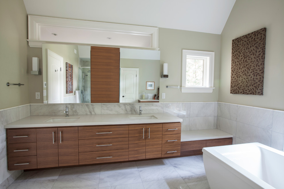 This is an example of a large modern master bathroom in Toronto with flat-panel cabinets, medium wood cabinets, quartzite benchtops, a freestanding tub, white tile, stone tile, beige walls and marble floors.