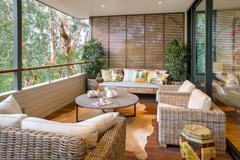 This is an example of a mid-sized tropical backyard verandah in Sydney with a roof extension.