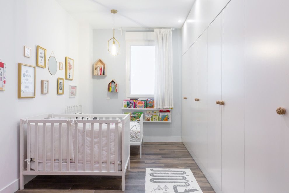 Nursery in Madrid with grey walls and brown floor for girls.