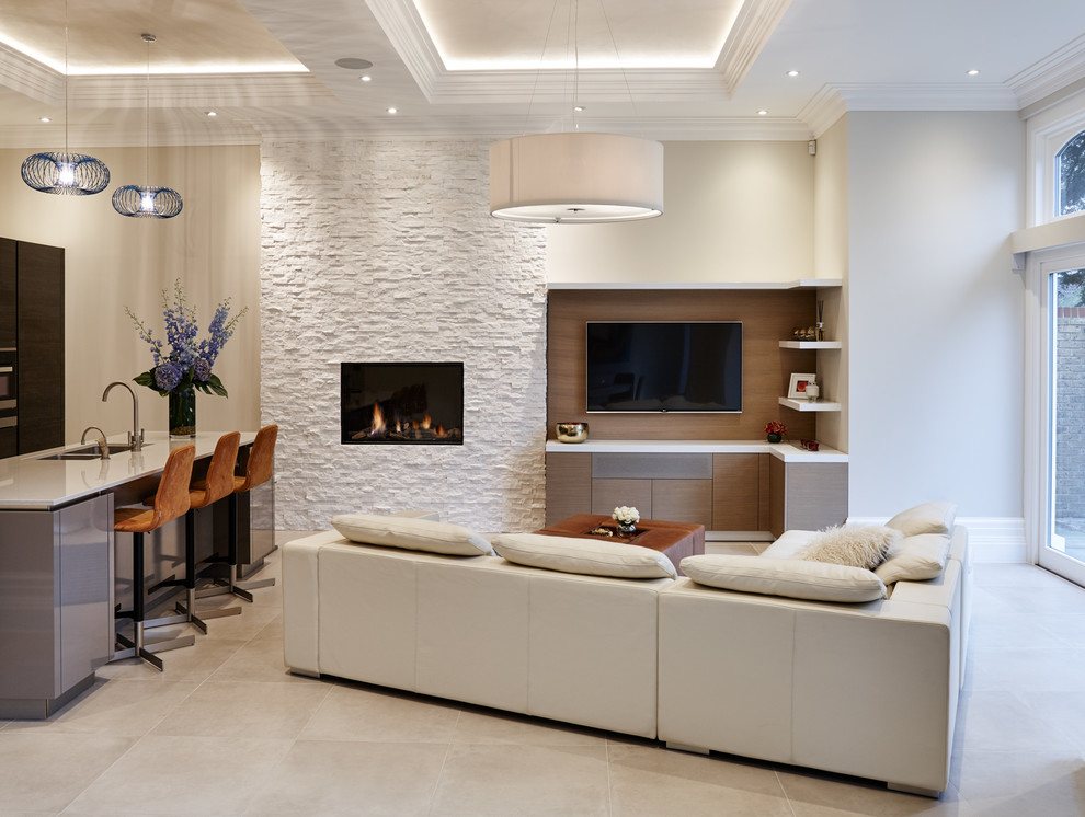 Design ideas for a contemporary open concept family room in Orange County with white walls, a standard fireplace, a stone fireplace surround and a wall-mounted tv.